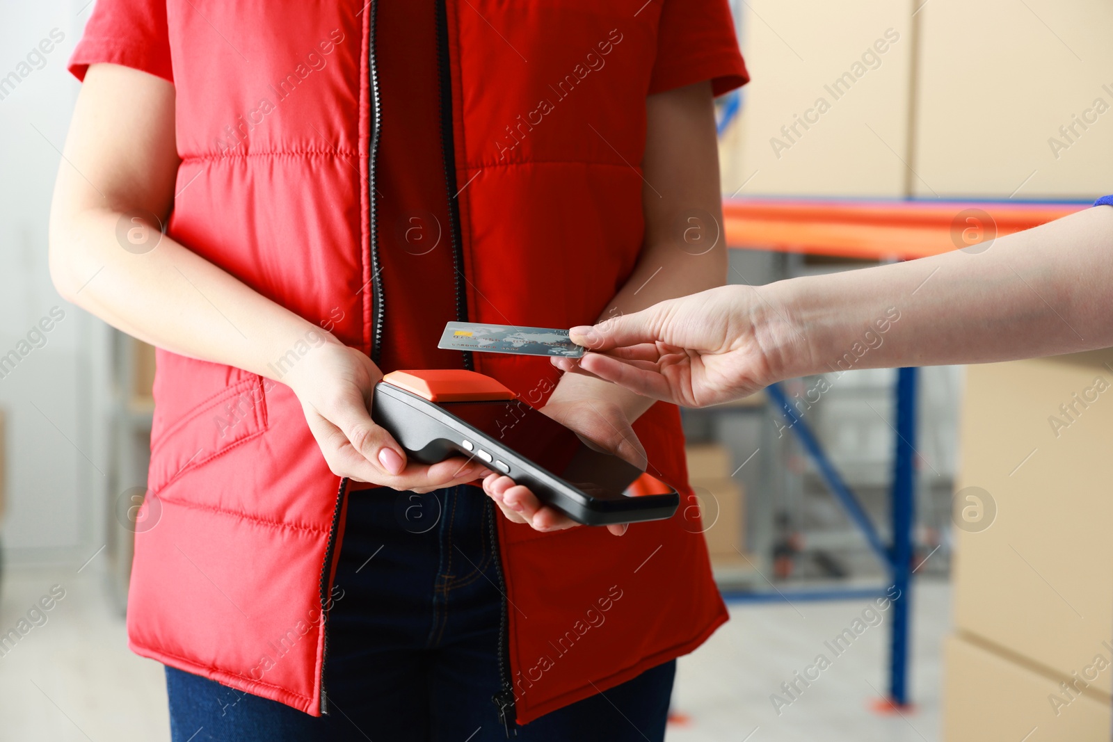 Photo of Woman paying for service with credit card via terminal indoors, closeup