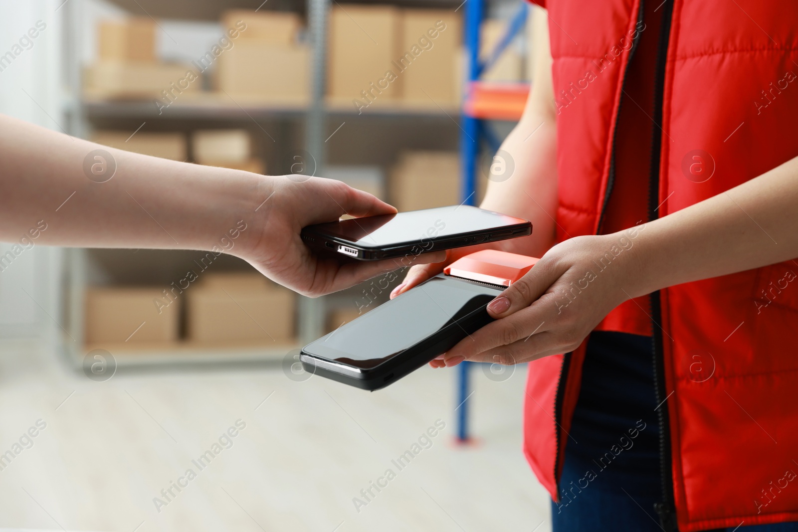 Photo of Woman paying for service with smartphone via terminal indoors, closeup