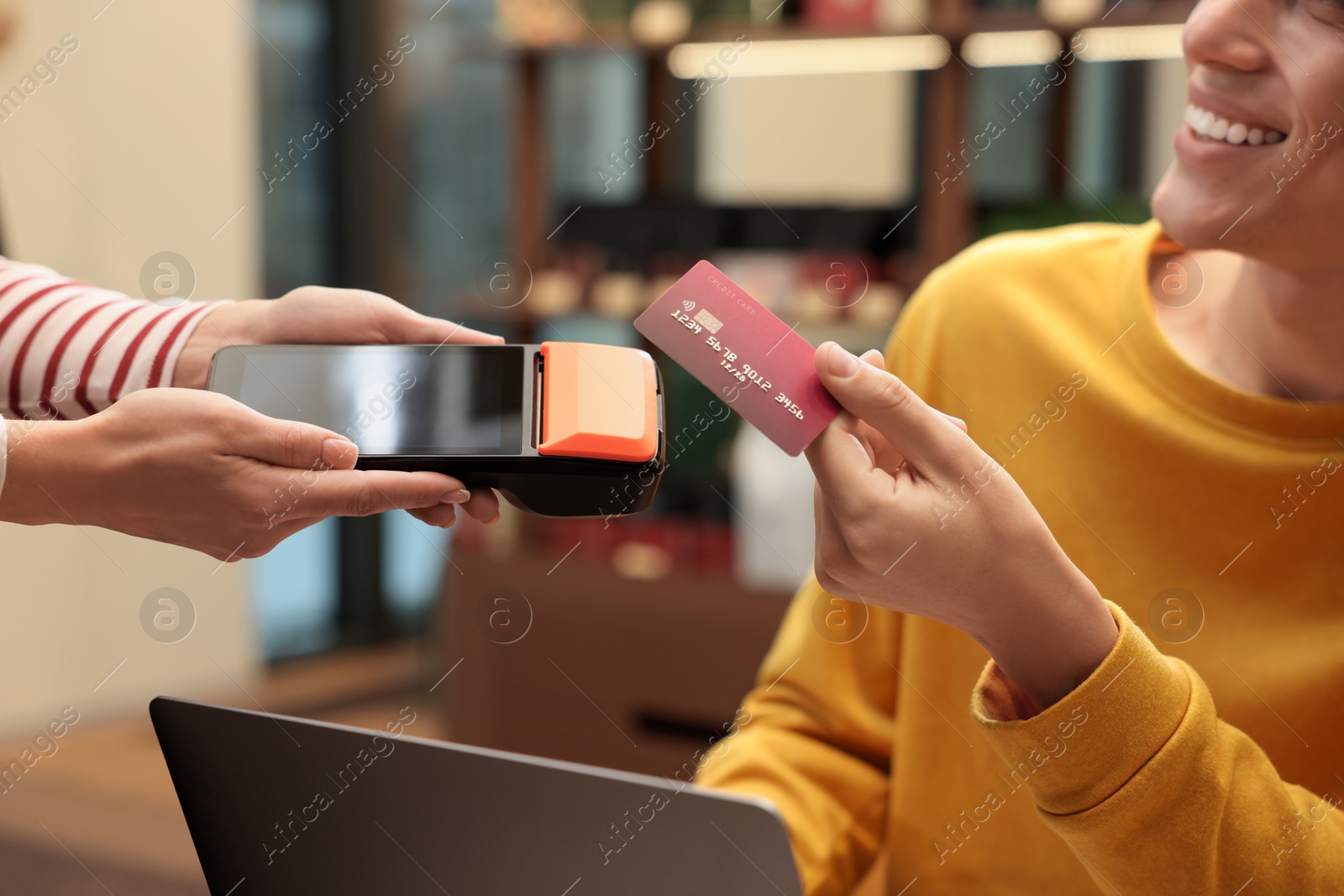 Photo of Man paying with credit card via terminal in cafe, closeup