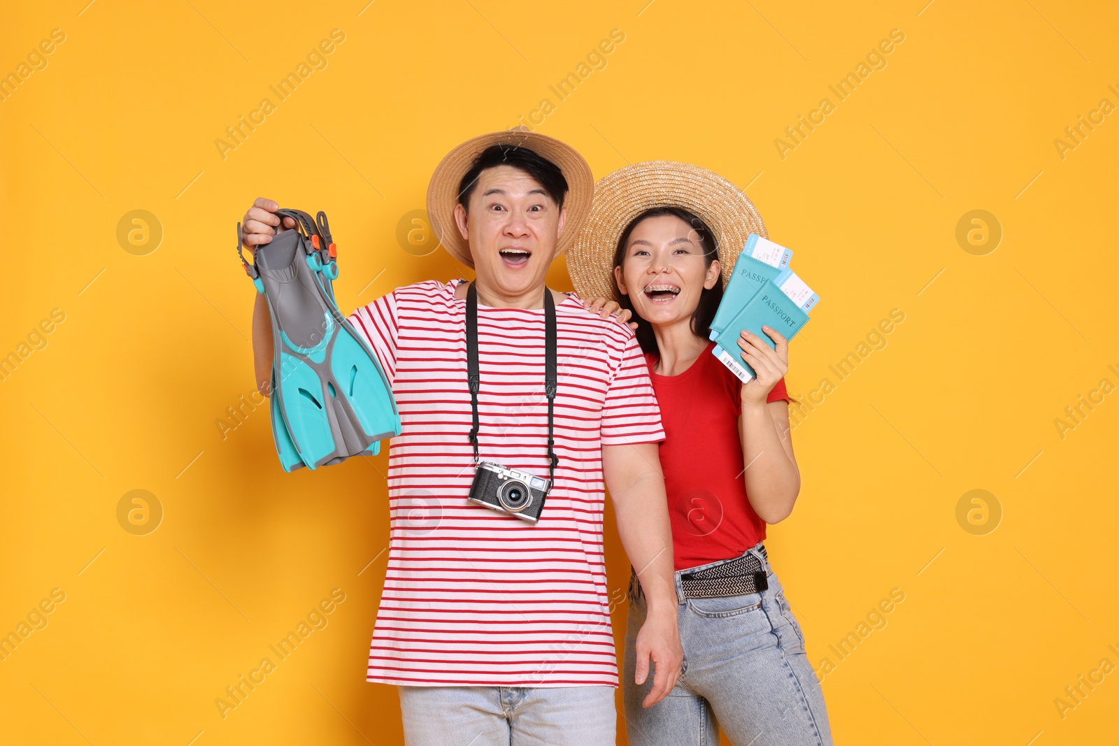 Photo of Excited travellers with passports and swim fins on yellow background