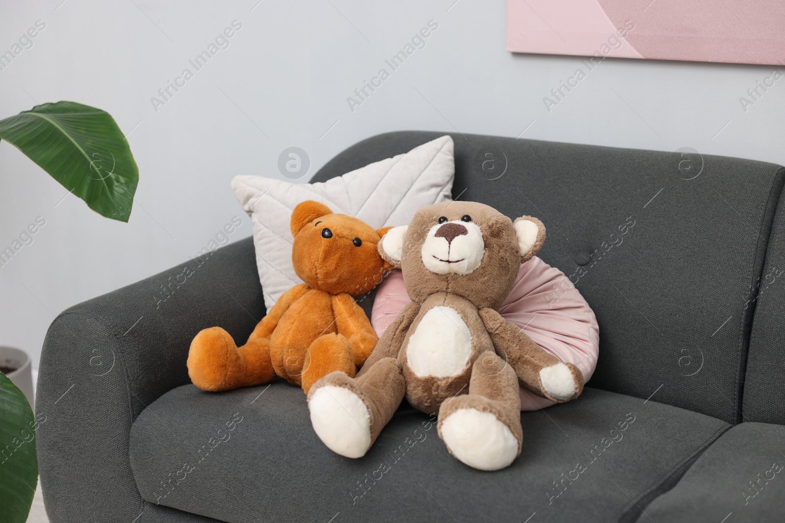 Photo of Teddy bears and pillows on sofa in room