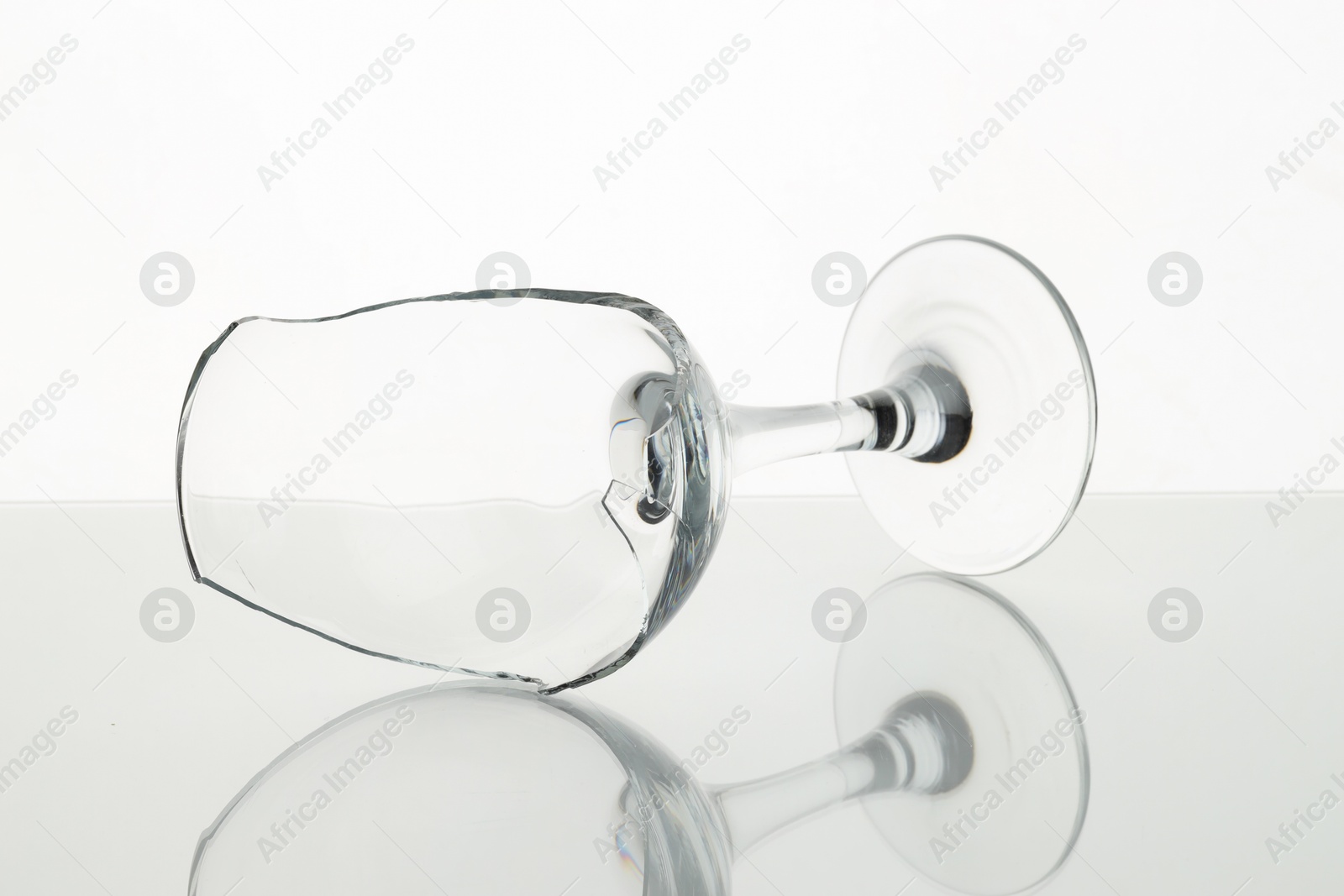 Photo of One broken wine glass on table against white background, closeup