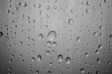 Photo of Water drops on grey glass surface, top view