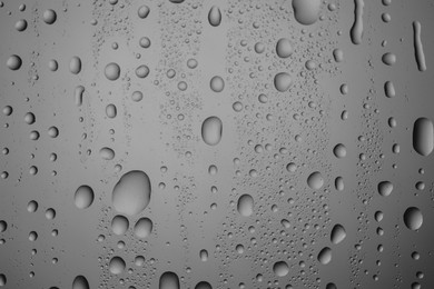 Water drops on grey glass surface, top view