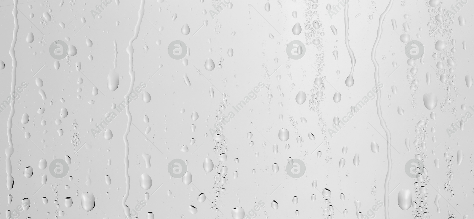 Photo of Water drops on light grey glass surface, top view