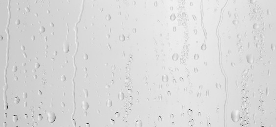 Photo of Water drops on light grey glass surface, top view