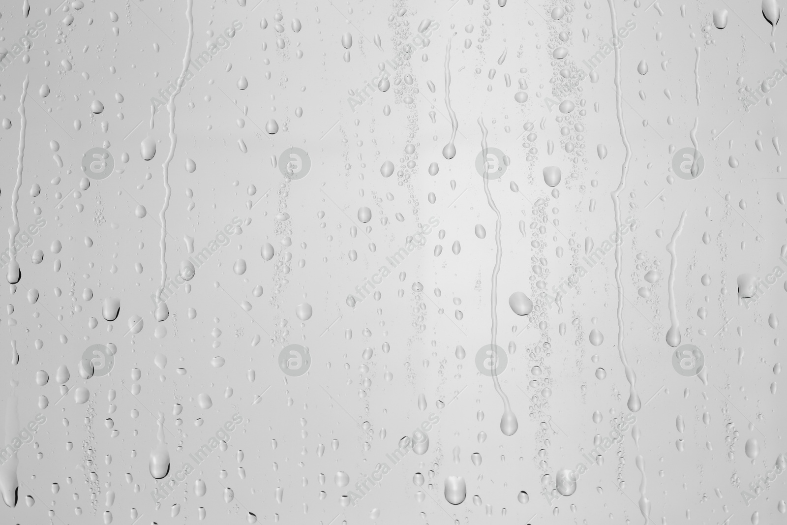 Photo of Water drops on light grey glass surface, top view