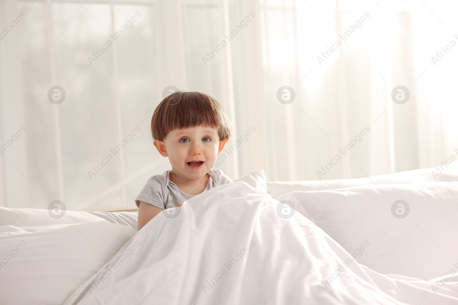 Photo of Cute little boy in bed at home