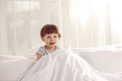 Photo of Cute little boy in bed at home