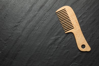 Photo of One wooden hair comb on grey background, top view. Space for text