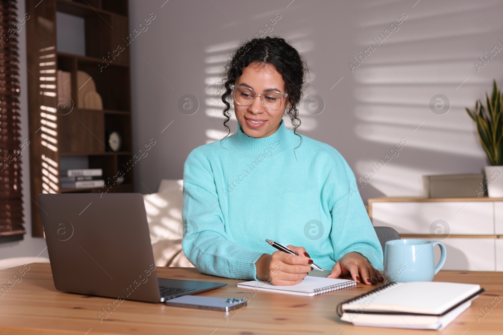 Photo of Beautiful woman working on laptop at desk in home office