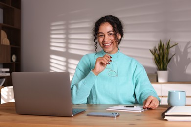 Photo of Beautiful woman working on laptop at desk in home office