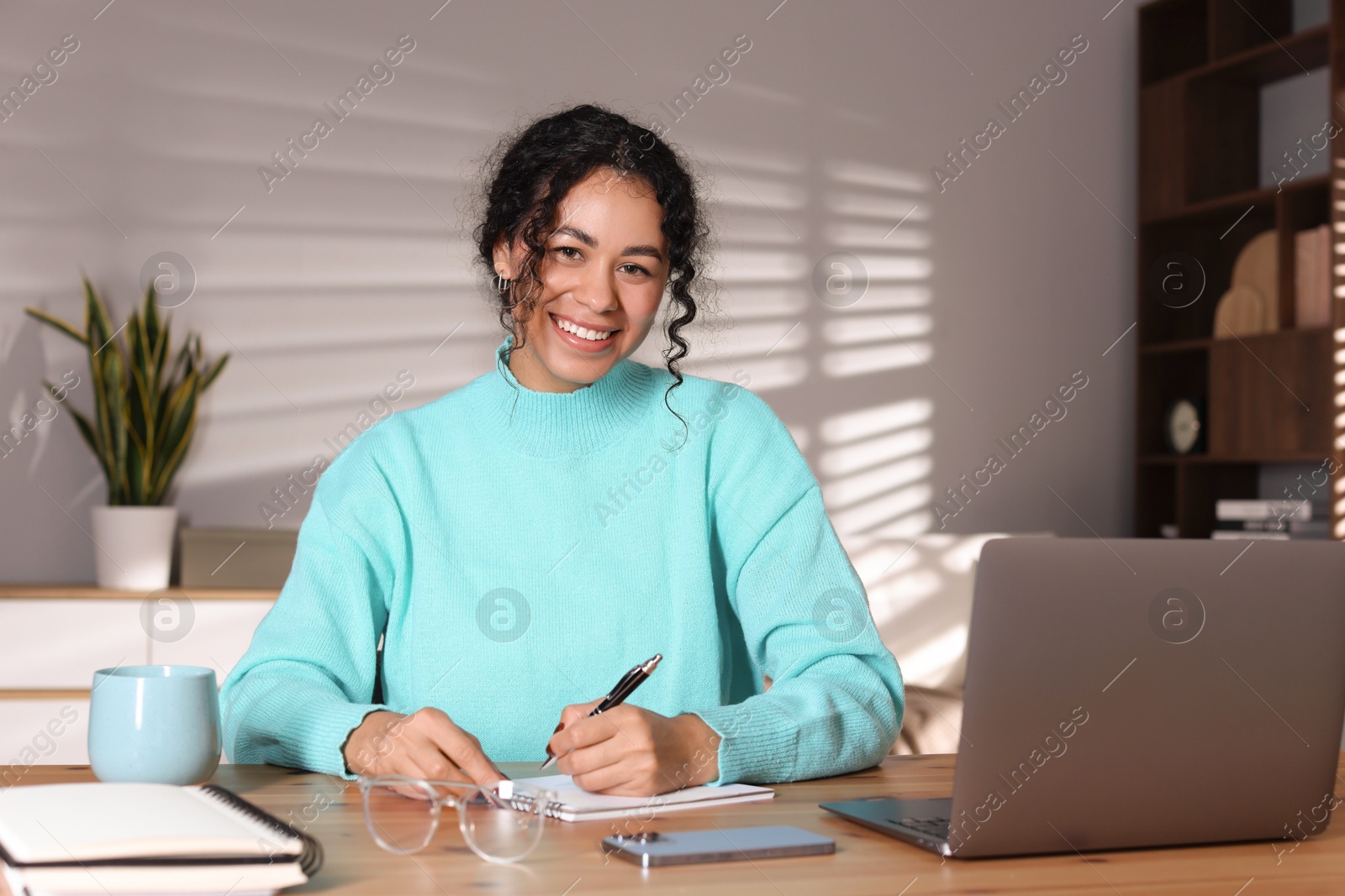 Photo of Beautiful woman working on laptop at desk in home office