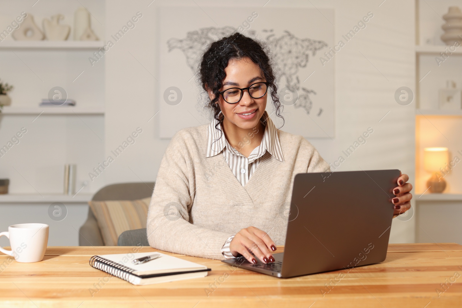 Photo of Beautiful woman working on laptop at desk in home office