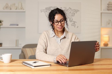 Beautiful woman working on laptop at desk in home office