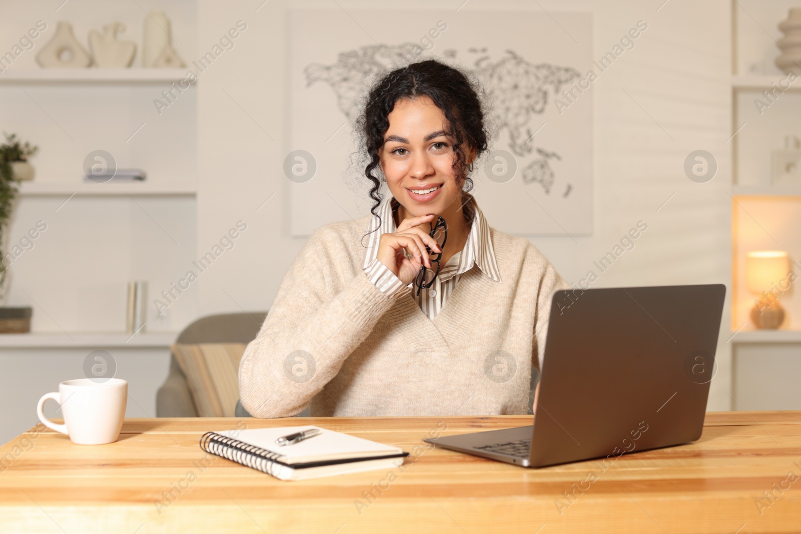 Photo of Beautiful woman working on laptop at desk in home office