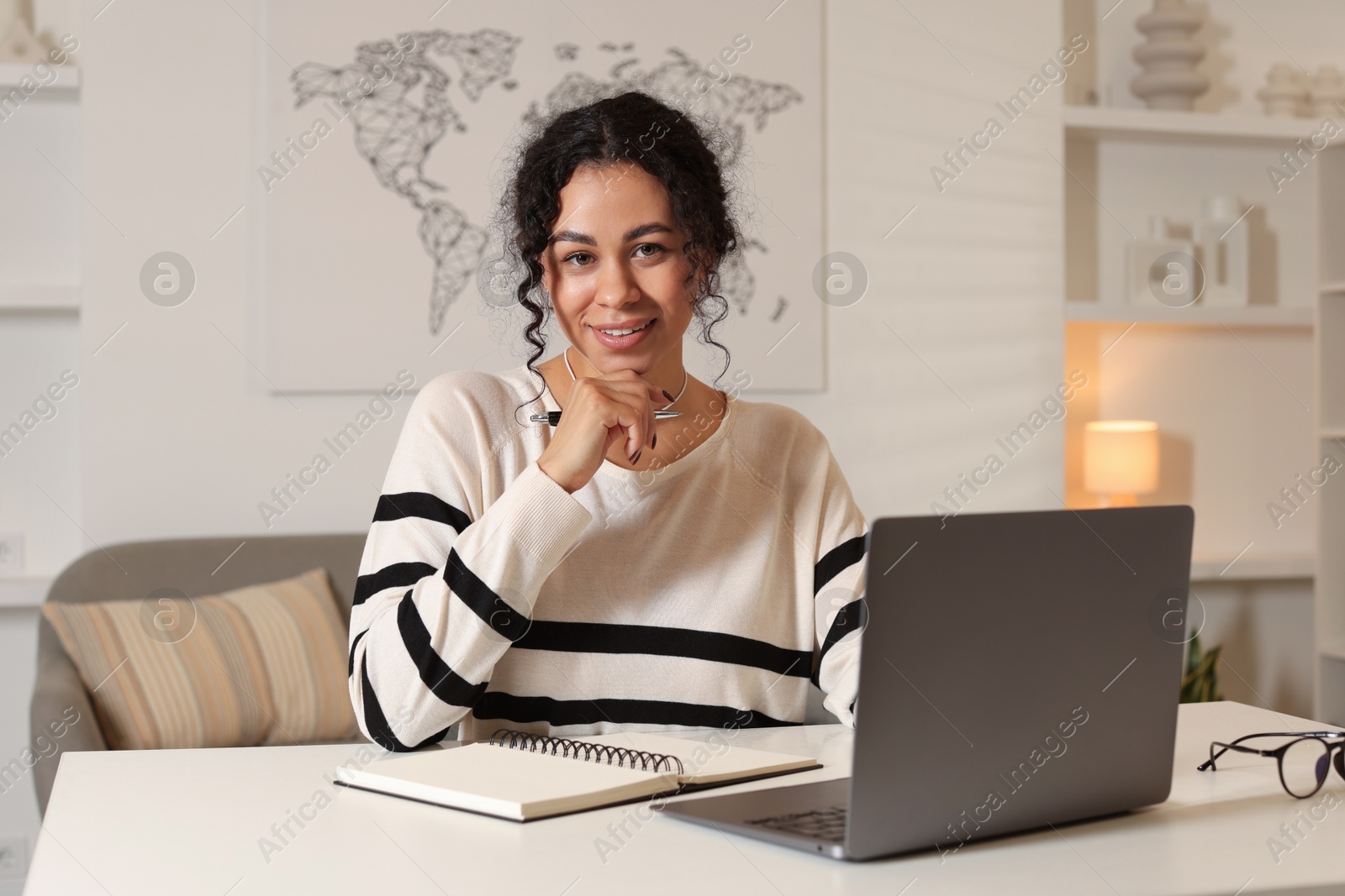 Photo of Beautiful woman working on laptop at desk in home office