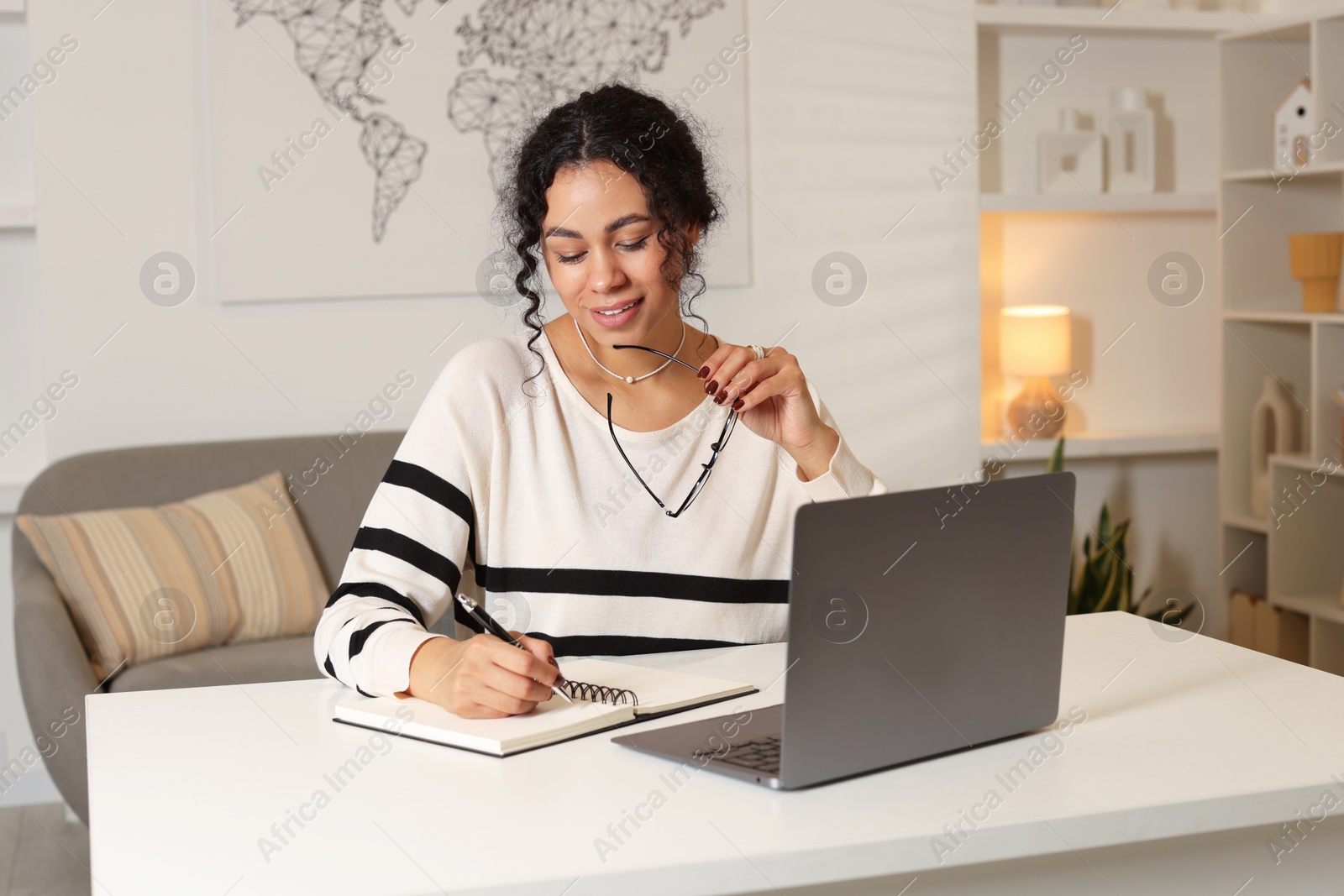 Photo of Beautiful woman working on laptop at desk in home office