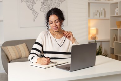 Beautiful woman working on laptop at desk in home office