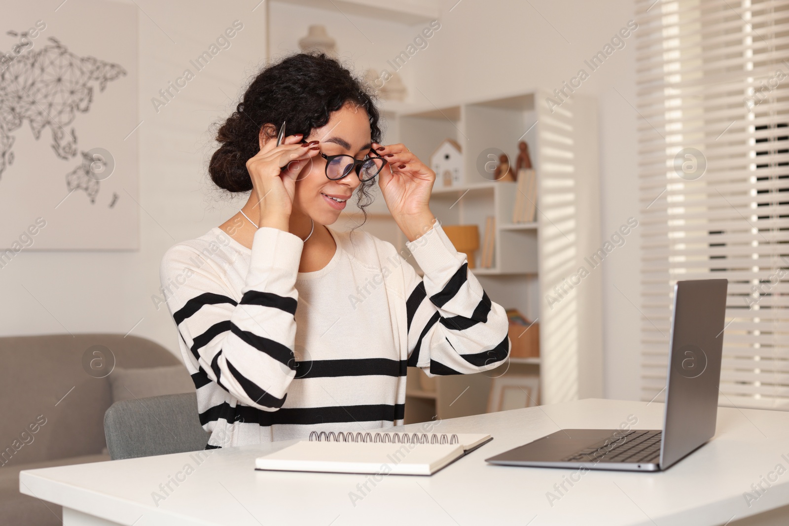 Photo of Beautiful woman working on laptop at desk in home office