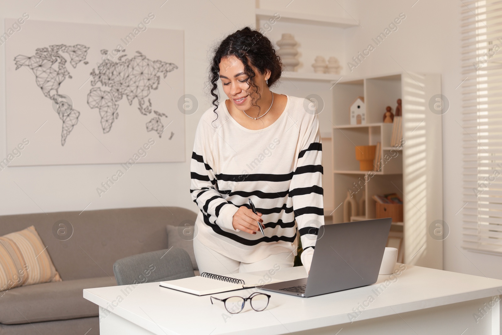 Photo of Beautiful woman working on laptop at desk in home office