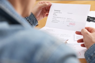 Photo of Paying bills. Man with invoice at table, closeup