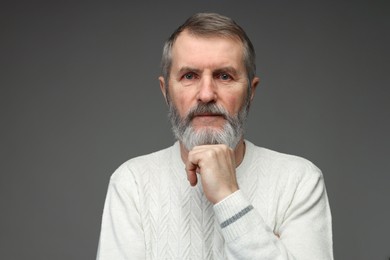 Photo of Portrait of mature man on grey background