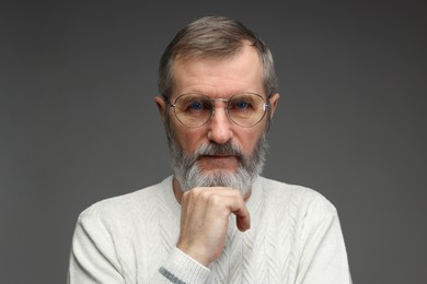 Photo of Portrait of mature man in glasses on grey background