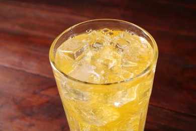 Photo of Sweet soda water with ice cubes in glass on table, closeup