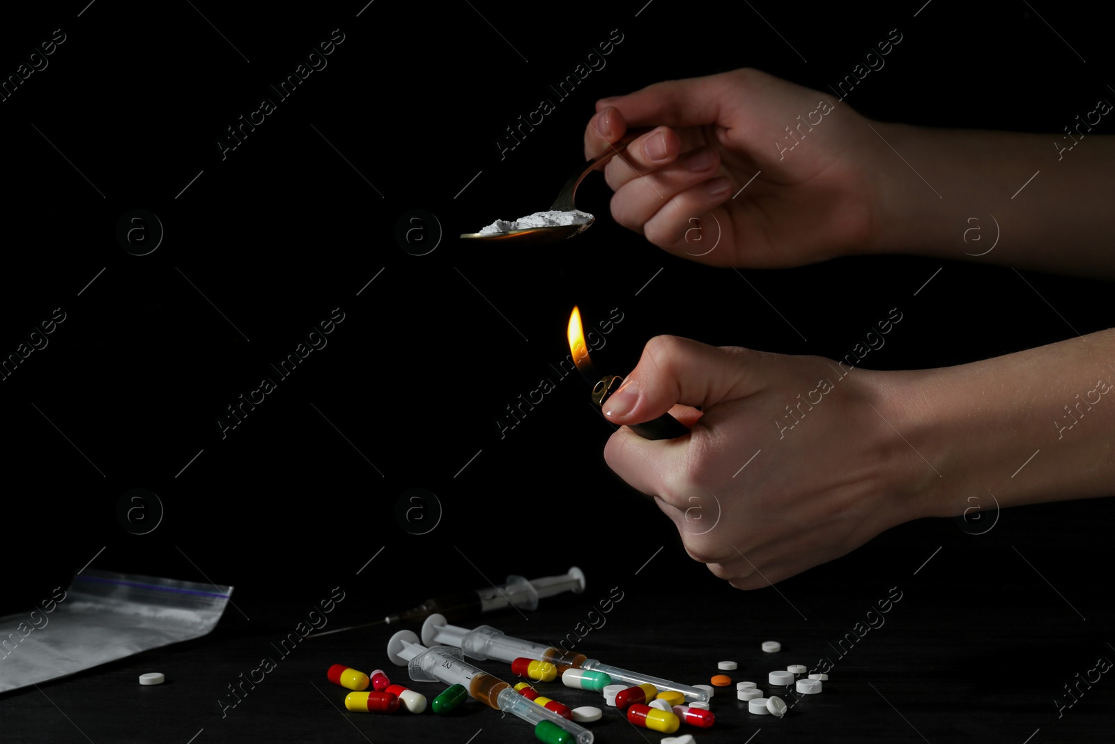 Photo of Drug addiction. Woman lighting spoon with powder against dark background, closeup. Space for text