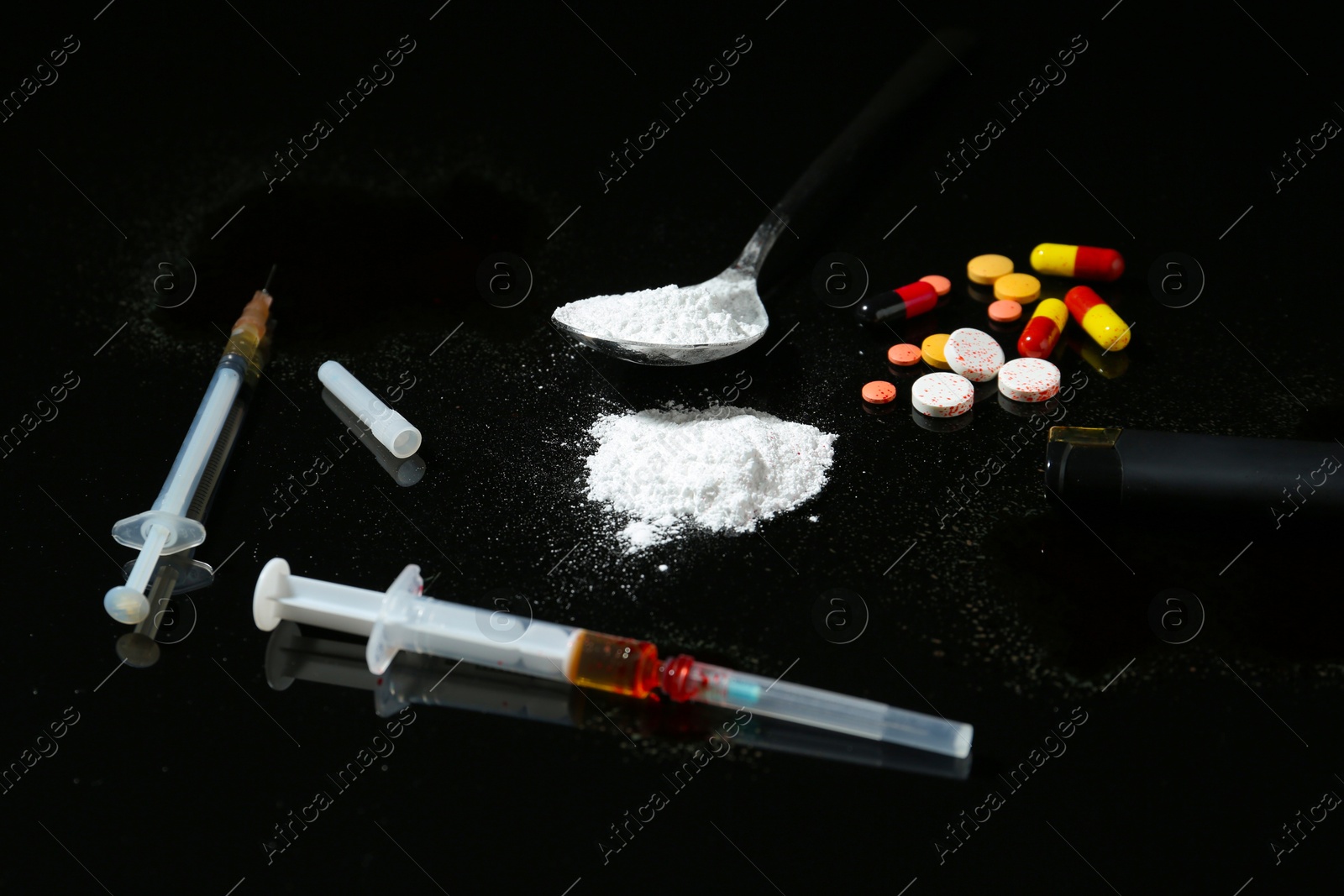 Photo of Drug addiction. Spoon with powder, pills and cigarette lighter on black table