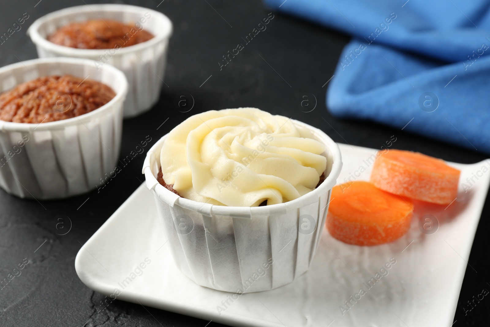 Photo of Delicious carrot muffins with fresh vegetable on grey table, closeup