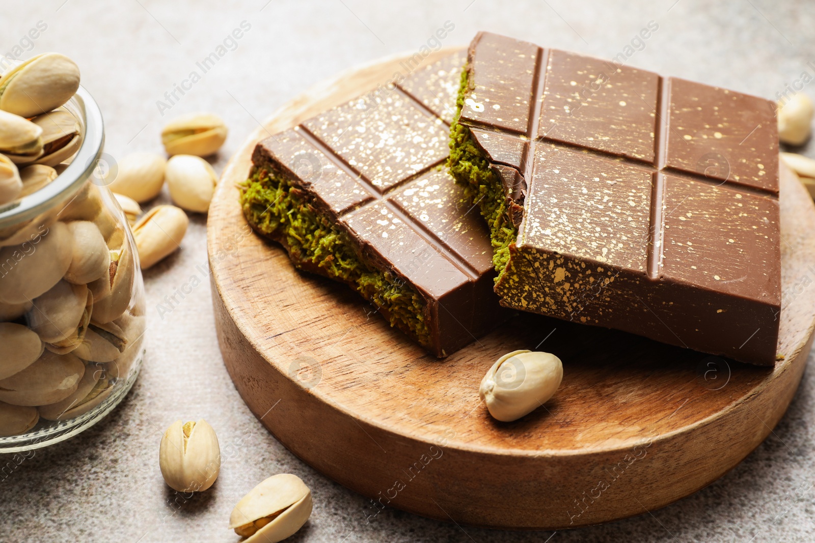 Photo of Pieces of Dubai chocolate bar with pistachios and knafeh on grey table