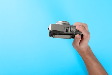 Photo of Photographer with vintage camera on light blue background, above view. Space for text