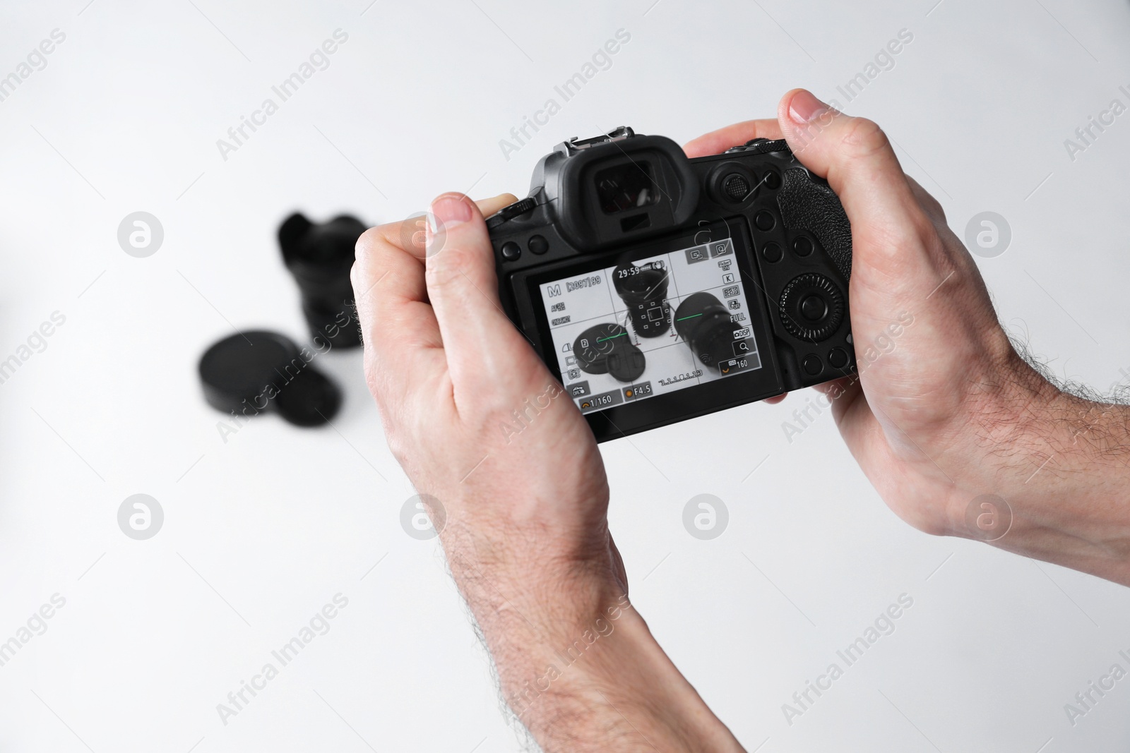 Photo of Photographer taking photo with professional camera on white background, closeup