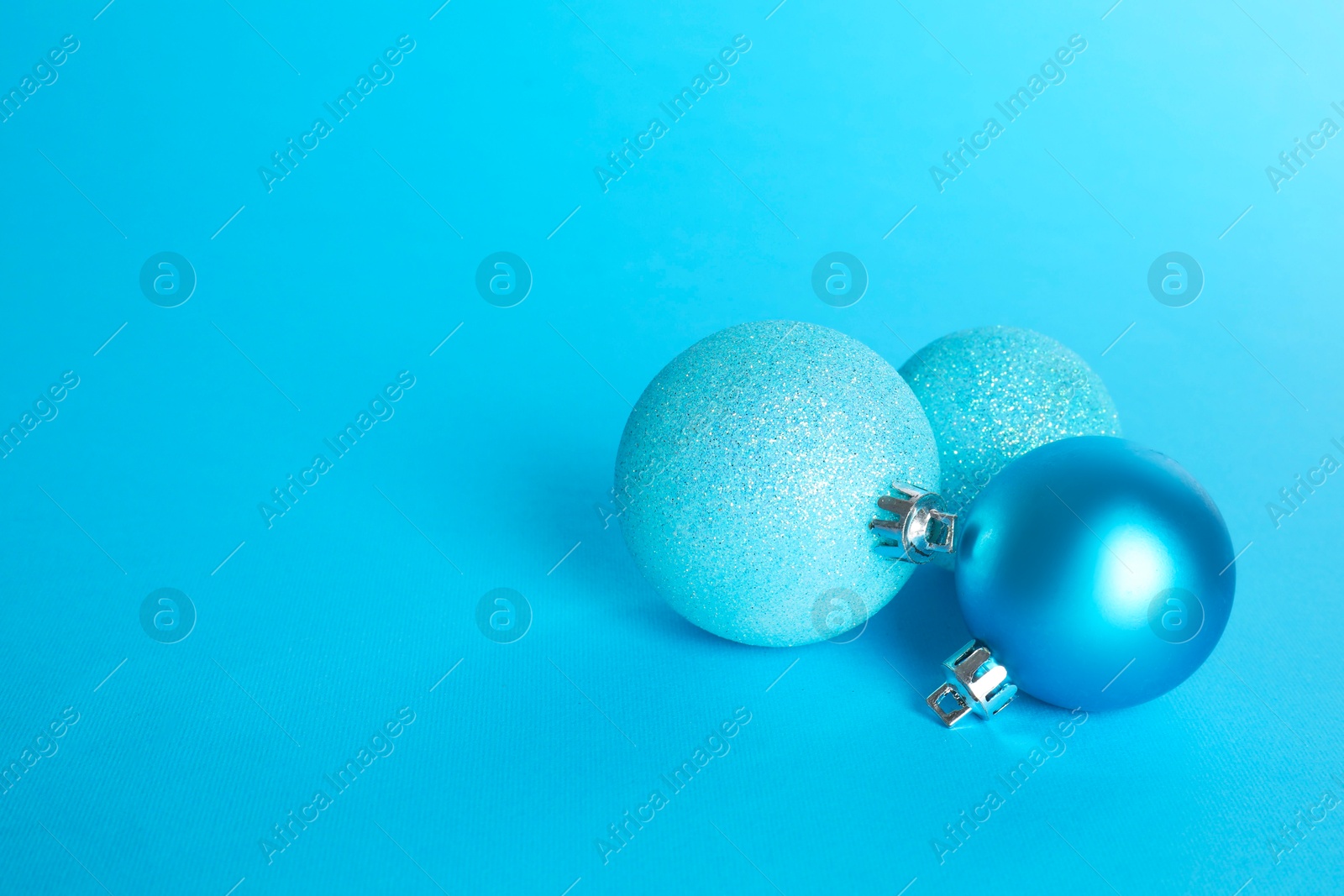 Photo of Beautiful Christmas balls on light blue background, space for text