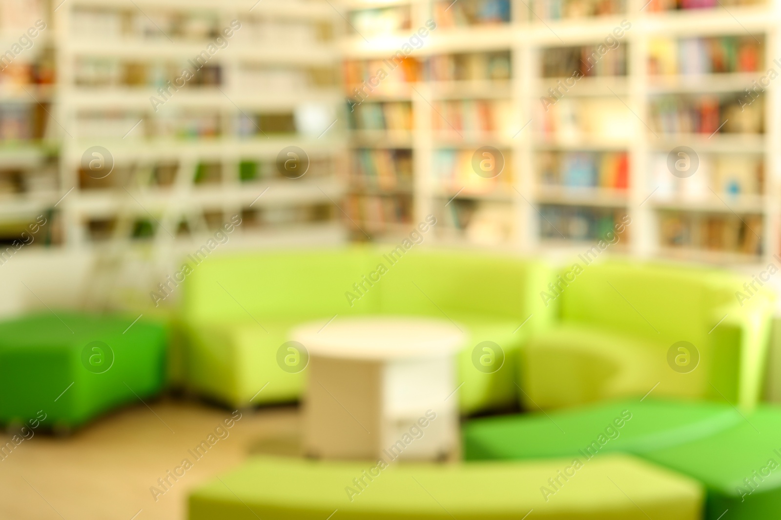 Photo of Stylish furniture in public library, blurred view