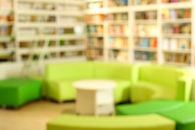 Photo of Stylish furniture in public library, blurred view