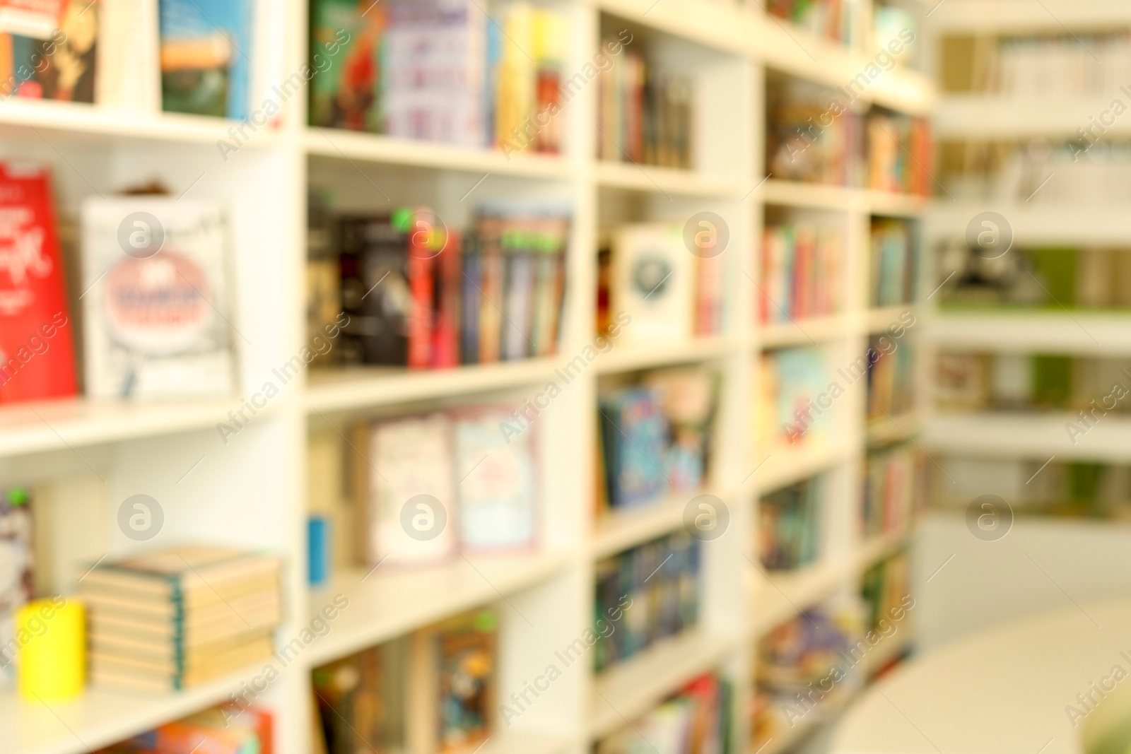 Photo of Bookcase with books in public library, blurred view