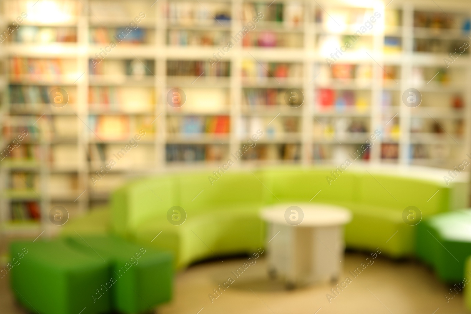 Photo of Stylish furniture in public library, blurred view