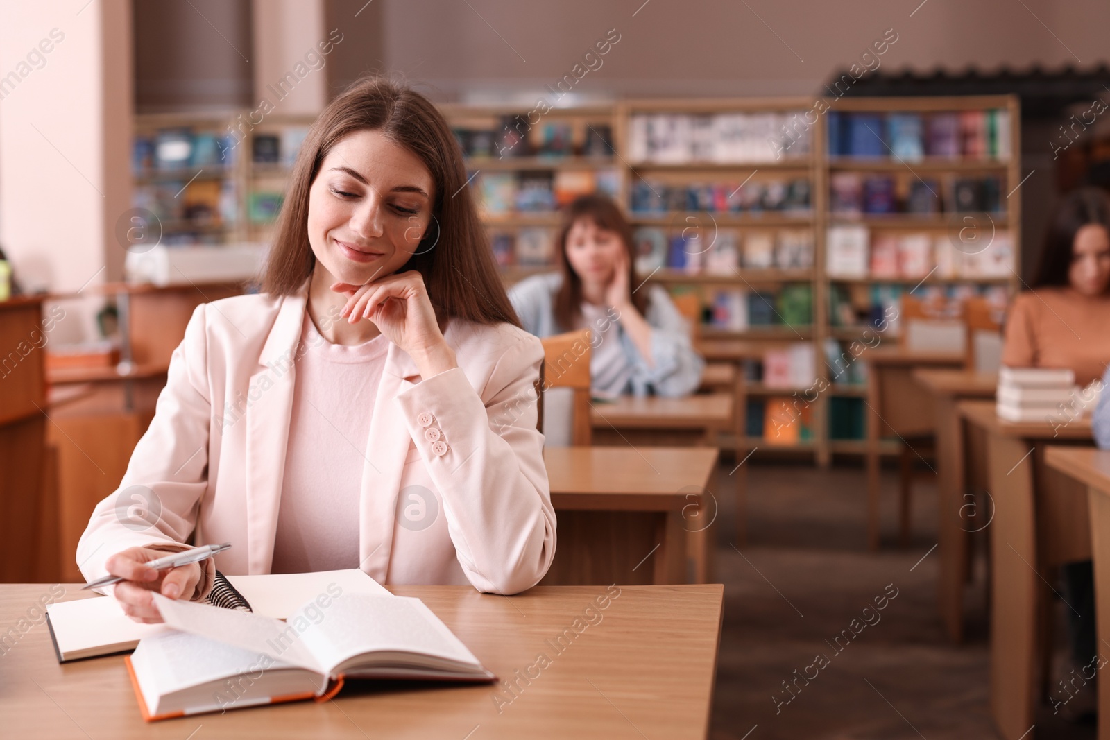 Photo of Beautiful woman in public library, space for text