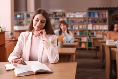 Photo of Beautiful woman in public library, space for text