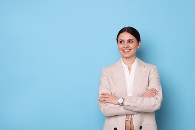 Photo of Portrait of banker with crossed arms on light blue background, space for text