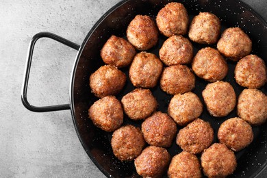 Photo of Tasty meatballs in baking dish on grey table, top view