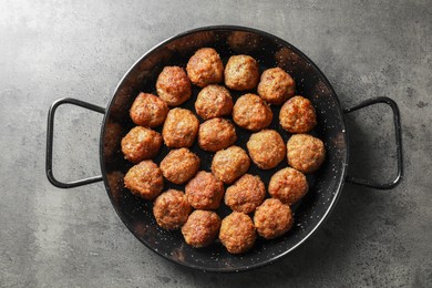 Photo of Tasty meatballs in baking dish on grey table, top view