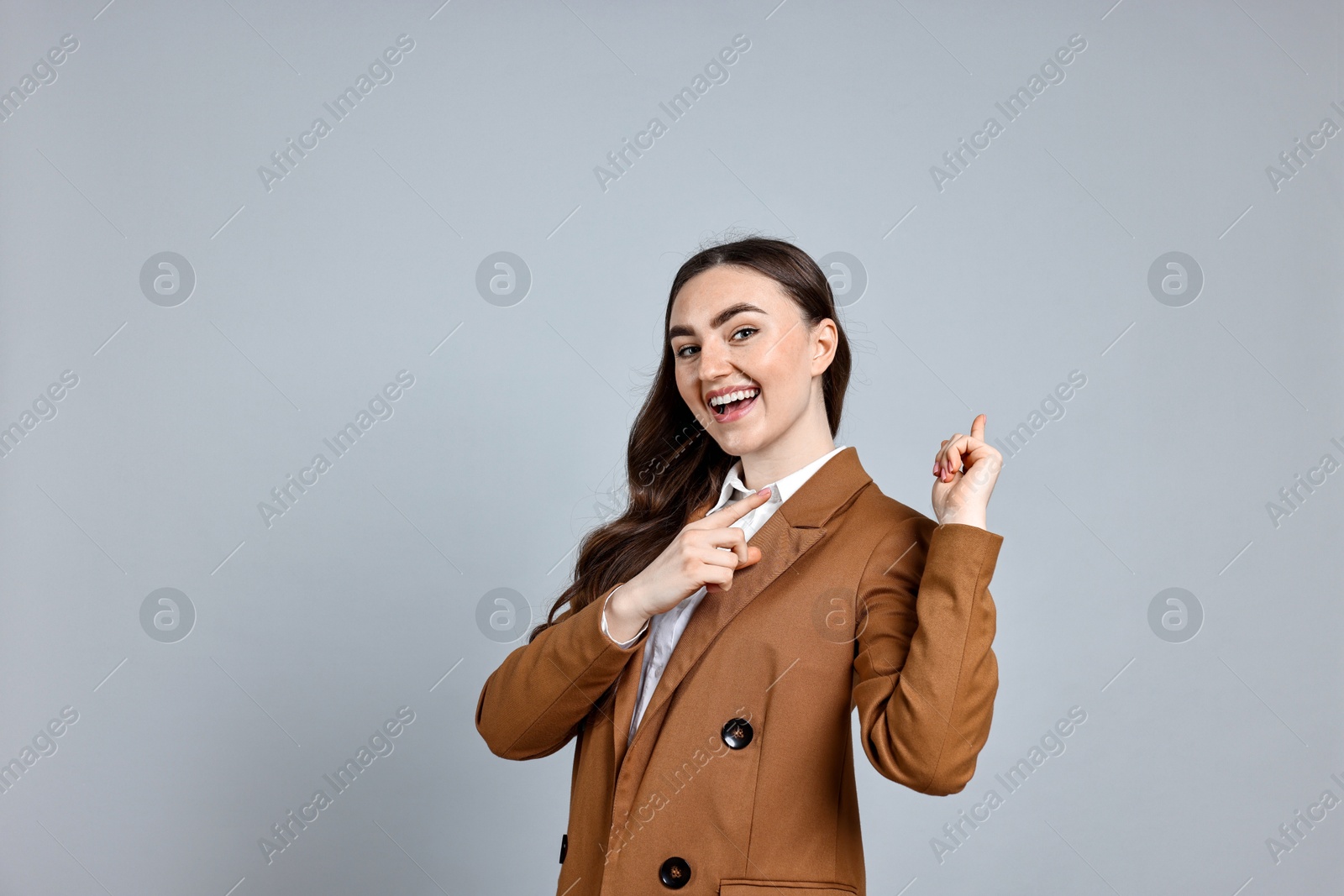 Photo of Happy businesswoman welcoming clients or partners on grey background. Space for text