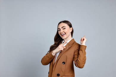 Photo of Happy businesswoman welcoming clients or partners on grey background. Space for text