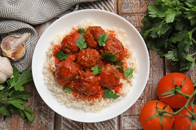 Photo of Tasty meatballs with sauce, rice and products on wooden table, flat lay