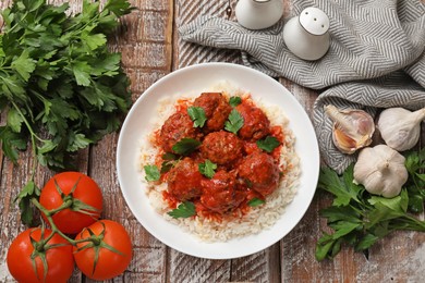 Photo of Tasty meatballs with sauce, rice and products on wooden table, flat lay