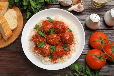 Photo of Tasty meatballs with sauce, rice and products on wooden table, flat lay